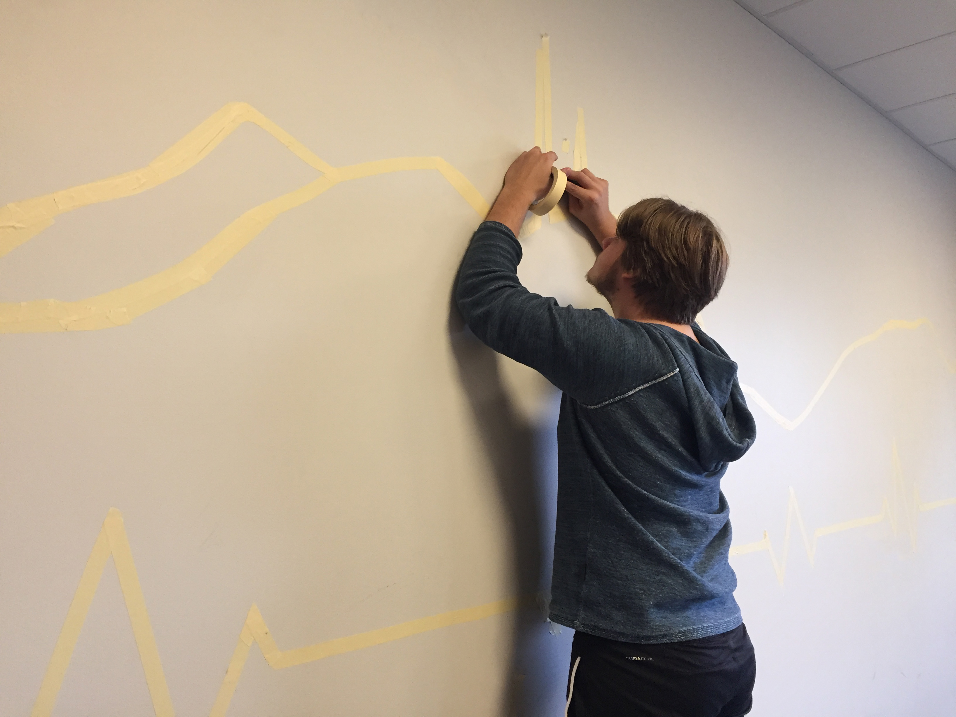 Det er viktig å planlegge før man starter å male! Her jobber Martin på veggen i kondisjonsrommet.